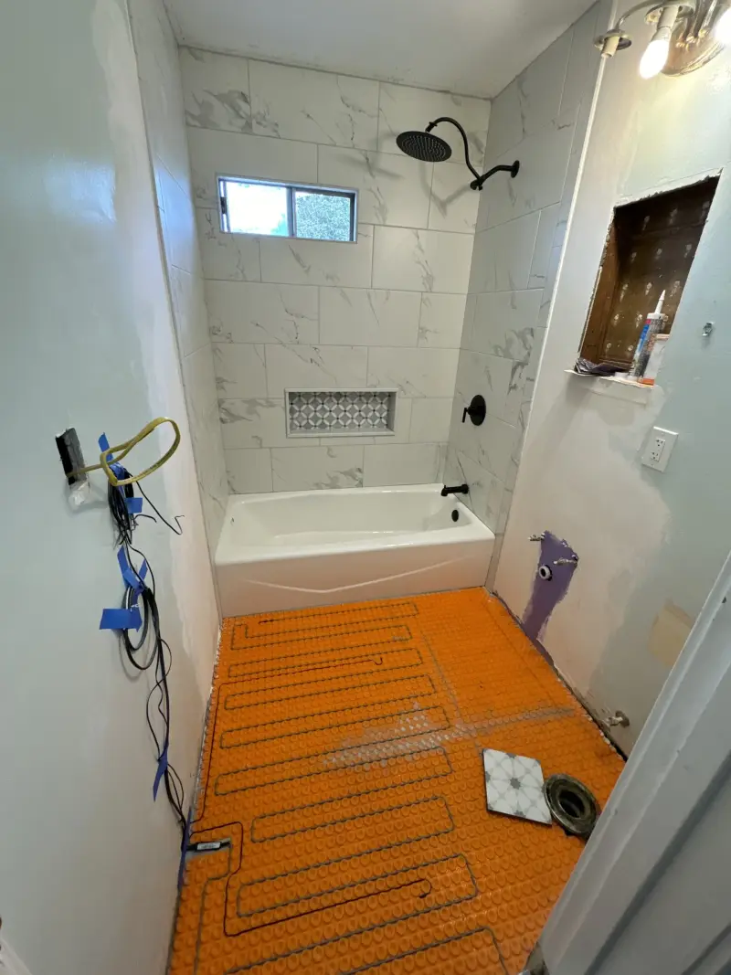 Bathroom remodel in progress with a membrane laid over the floor before new tile