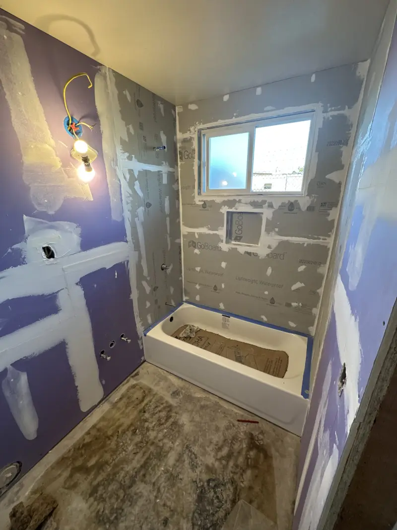 New tub set in place with moisture-resistant drywall before tile