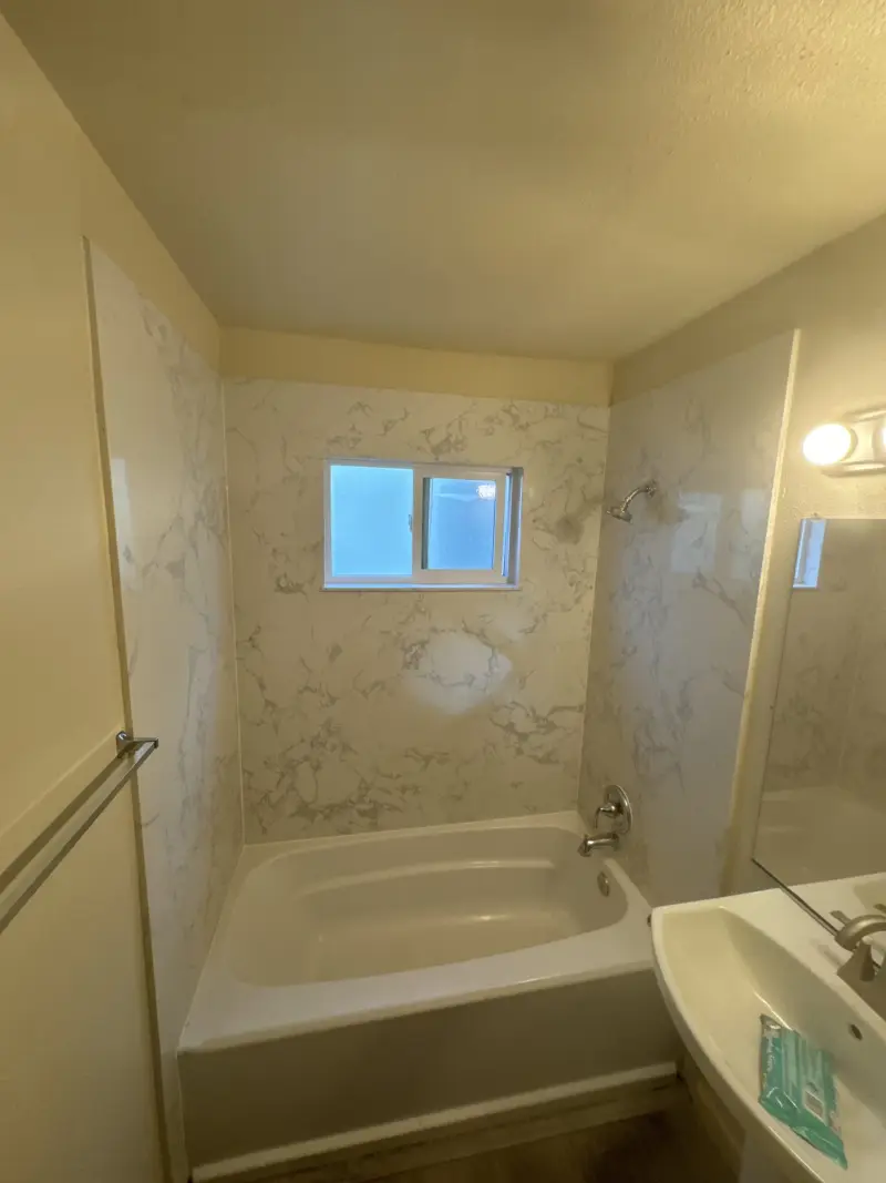 Bathtub surround finished in large-format marble-look tile