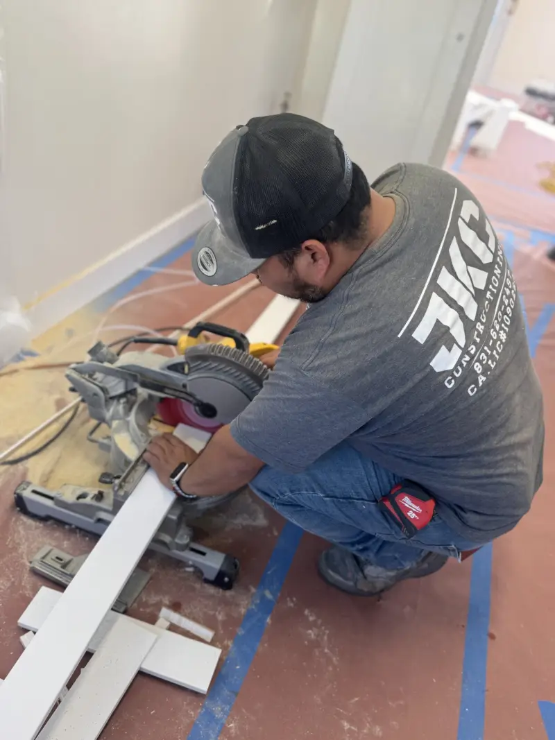 JKC Construction crew member cutting trim on site