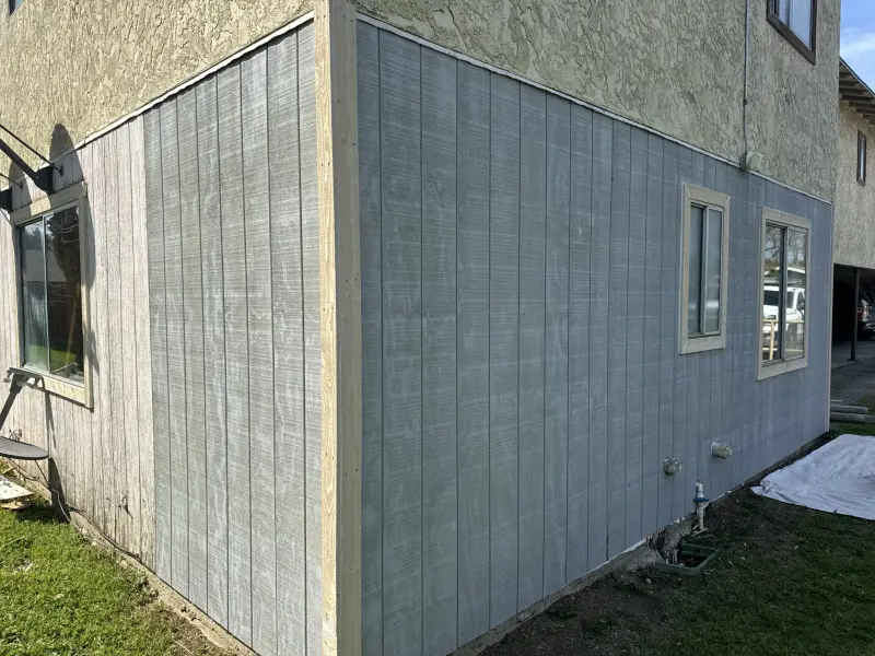 Exterior wall finished with new gray panel siding